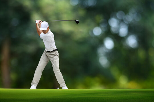 Golfer driver back swing before hitting golf ball.