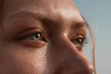 Close-up of a beautiful girl's eyes in the sun looking into the distance