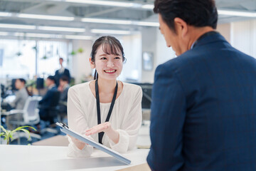 窓口で来客の対応をする女性スタッフ