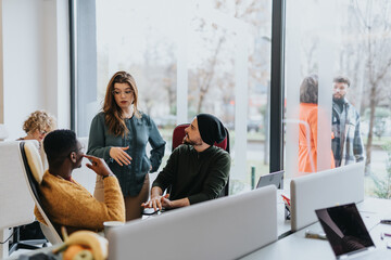 A mixed race team of enthusiastic and successful entrepreneurs collaborating and discussing innovative strategies for business growth and profitability in a modern office workplace.