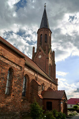 Fototapeta premium Historic church with a red brick bell tower in Lubniewice