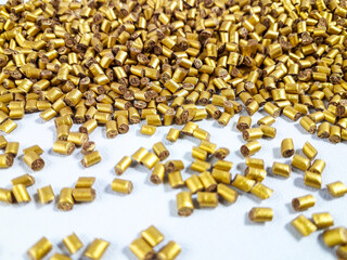 Gold masterbatch granules on white background.Color pigment carrier polymer in plastic industry