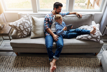 Man, boy and tablet on couch with internet for educational gaming, movie bonding and online tv...