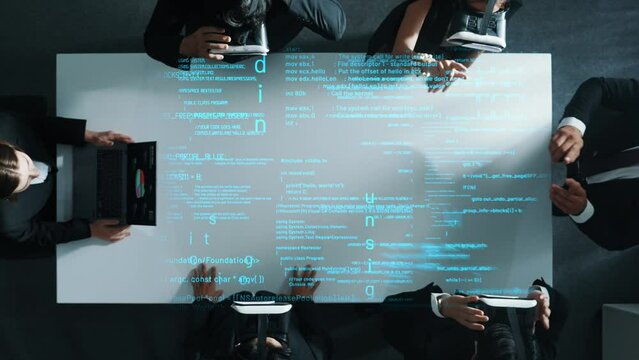 Top view of diverse data analysts wearing VR headsets stands coding program holographic while using hand gestures to manipulate programing engineering prompt from the manager laptop. Directorate.