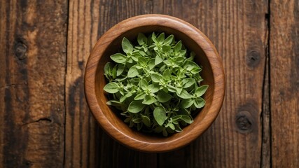 top view of oregano in a small wooden plate isolated o background