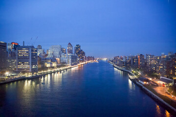 Fototapeta premium New York City, New York, USA - Drone view of the East River, Roosevelt Island, the FDR drive with the Triboro Bridge in the distance