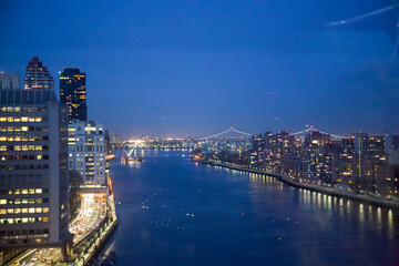 Naklejka premium New York City, New York, USA - Drone view of the East River, Roosevelt Island, the FDR drive with the Triboro Bridge in the distance