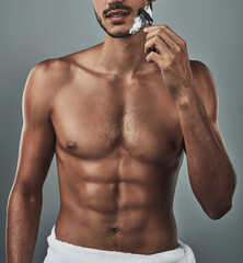 Grooming, man and shaving face in studio in topless, abs and epilation on gray background. Male person, skincare and razor for hair removal with healthy body, six pack and routine or transformation