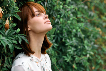 Dreaming under the open sky woman gazes up at the clouds against a vibrant green backdrop