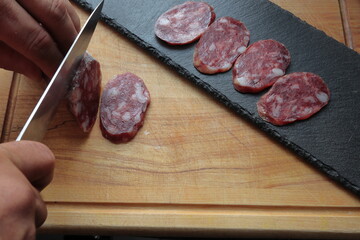 mano cortando embutido aperitivo tapa pincho