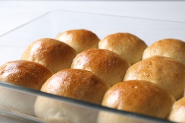 Delicious dough balls in baking dish on table, closeup