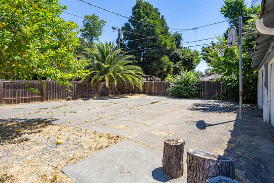 A empty backyard with a large cement patio and a blue sky. Great for virtual staging