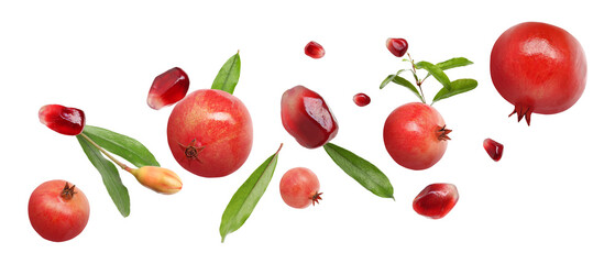 Fresh pomegranates, seeds and leaves in air on white background