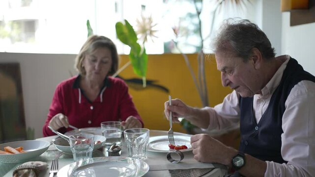 Cherished Moments - Couple Shares Delicious Meal, Seated at Stylish Balcony Table amid Flower Pots and Trees