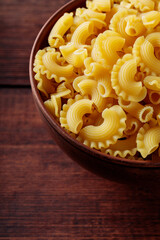 Dry Uncooked Italian Creste di Gallo Pasta in Bowl, Close Up