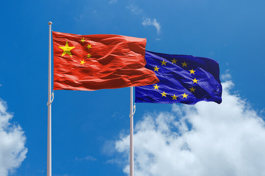China and EU flags above blue sky. China and Europe Union trade war. EU dutys for EV cars made in China