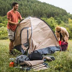 Couple pack a tent after finish camp trip