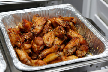 A view of a catering tray of dry rub chicken wings.