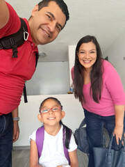 Dad, mom and 4-year-old Latin brunette daughter are ready to go to school and work, they take a photo to show their happiness on social media