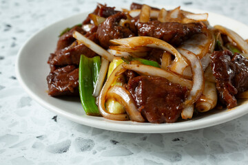 A top down view a plate of Mongolian beefsteak.