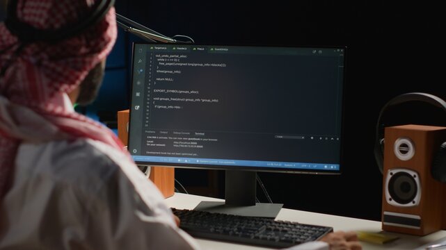 Certified arab engineer writing code on computer screen while in office using Java programming languages. Middle Eastern developer working on fixing database errors while working from apartment office