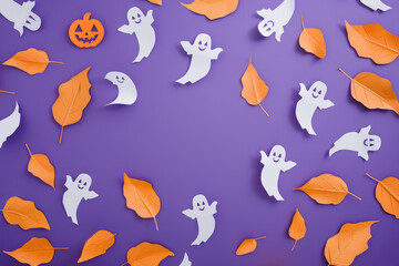 creative halloween paper decorations with ghosts and orange leaves on purple background