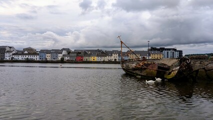 Fototapeta premium Cloudy Evening cityscape scenery, colourful houses at Long walk, Claddagh by Corrib river at Galway city, Ireland 