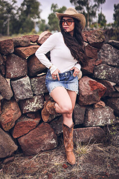 Mexican, western cowgirl with a whip in a sheriff hat. Vaquera Mexicana disfrutando el campo. piedras de campesina