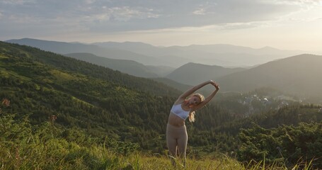Woman Meditating in the Mountains at Sunrise