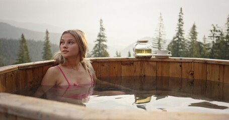 Beautiful Woman Relaxing in Hot Bath with Mountain Sunrise View, Rejuvenating in Nature