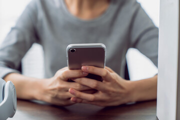 Woman holding a smartphone and using social media on internet.