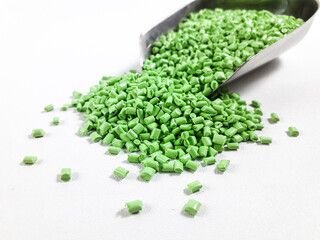 Matcha green masterbatch granules in scoop on white background.Color pigment carrier polymer in plastic industry