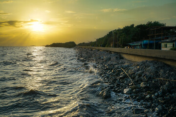 Sunset scenes over various bodies of water including a river, sea, and beach, with elements like clouds, waves, and rocks in a summer evening landscape