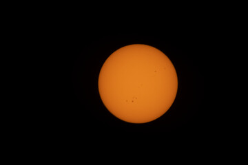 view of sun with sunspots through solar filter