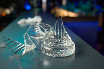 Numerous small glass shards scattered across a bar counter in a dimly lit setting