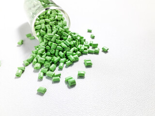 Matcha green masterbatch granules with glass tube on white background.Color pigment carrier polymer...