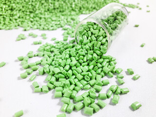 Matcha green masterbatch granules with glass tube on white background.Color pigment carrier polymer in plastic industry
