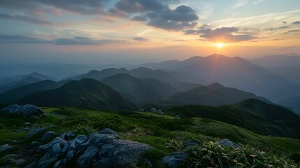 Obraz premium A serene sunrise over the rolling mountains creates a tranquil and breathtaking view.