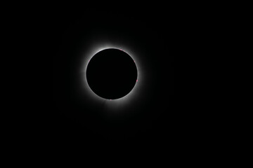 Corona surrounding the total eclipse with sun spots around the moon