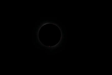 Corona surrounding the total eclipse with sun spots around the moon