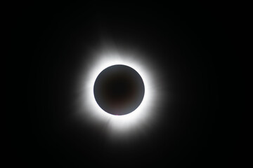 Light shining from sun around the moon creating a halo effect during the total eclipse