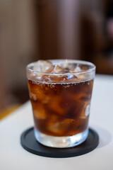 A glass of Cola on the table with blurred background