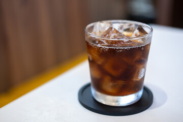 A glass of Cola on the table with blurred background