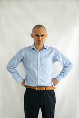 Angry and upset young businessman with his hands on his hips, looking furious