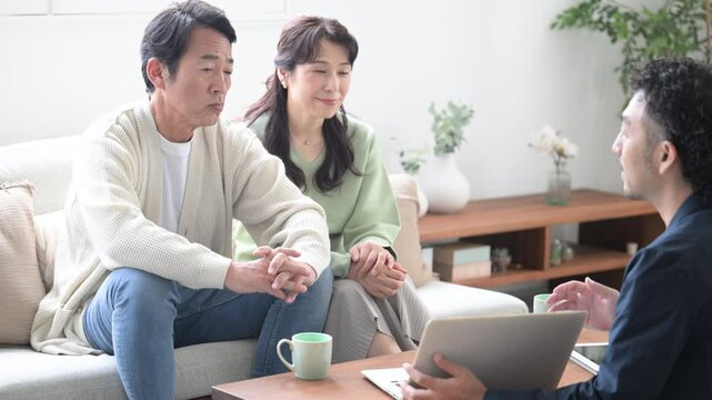 営業マンの説明を受ける笑顔の50代夫婦　投資や保険、不動産などの動画