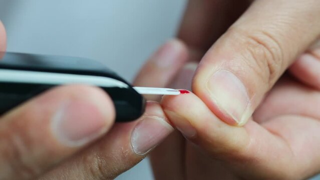 Woman's hands checking diabetes and hyperglycemia with digital blood sugar meter. Healthcare and medical concept