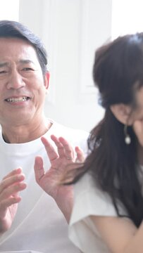 A well adjusted husband apologizing to his wife in a marital quarrel...it looks like he will never be forgiven no matter what...cheating, car, debt...close-up vertical video
