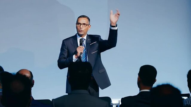 A businessman addresses the meeting from the podium 