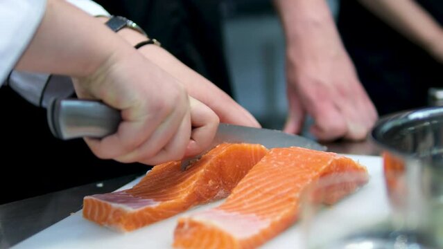 Step by step cut marinate fry serve delicious fresh red fish. Chef cooks fish steak in frying pan. Cooking in restaurant. Salmon steak preparation process