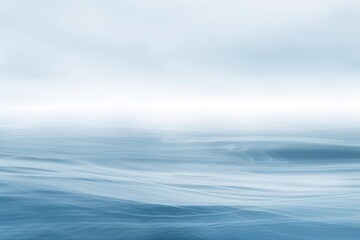Naklejka premium Calm ocean waves under soft blue sky creating a soothing and peaceful atmosphere